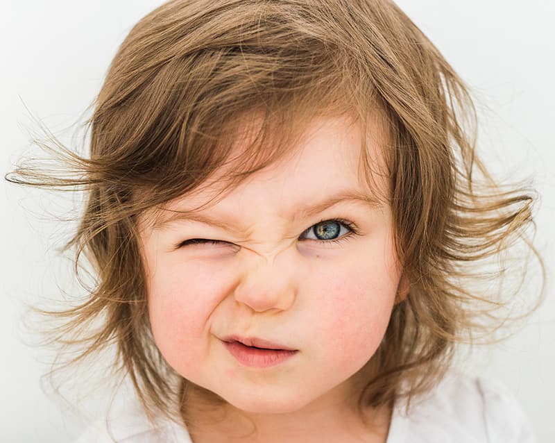 toddler face with one eye closed