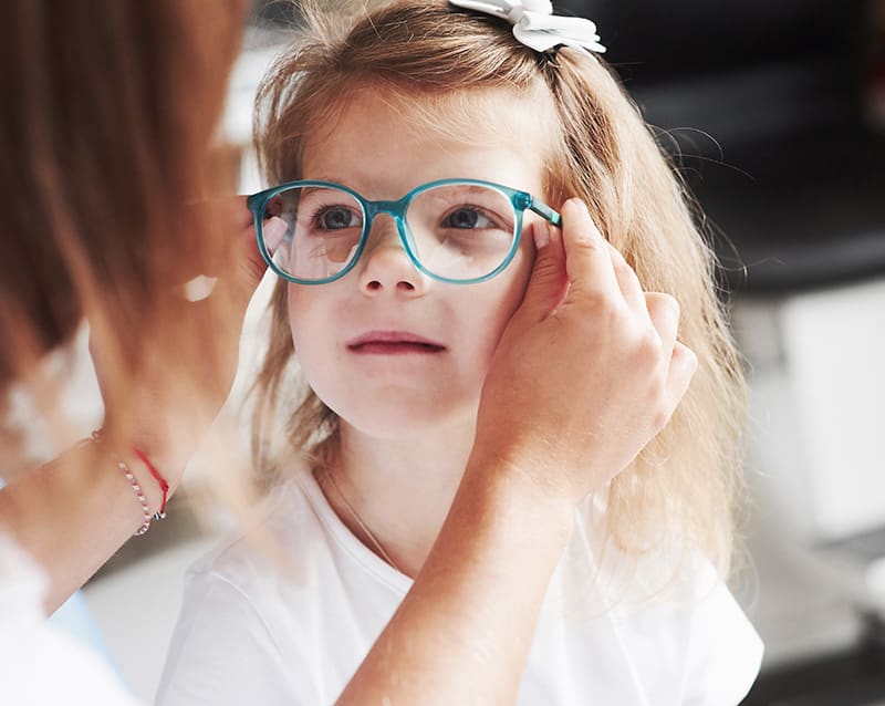 girl getting fitted for glasses