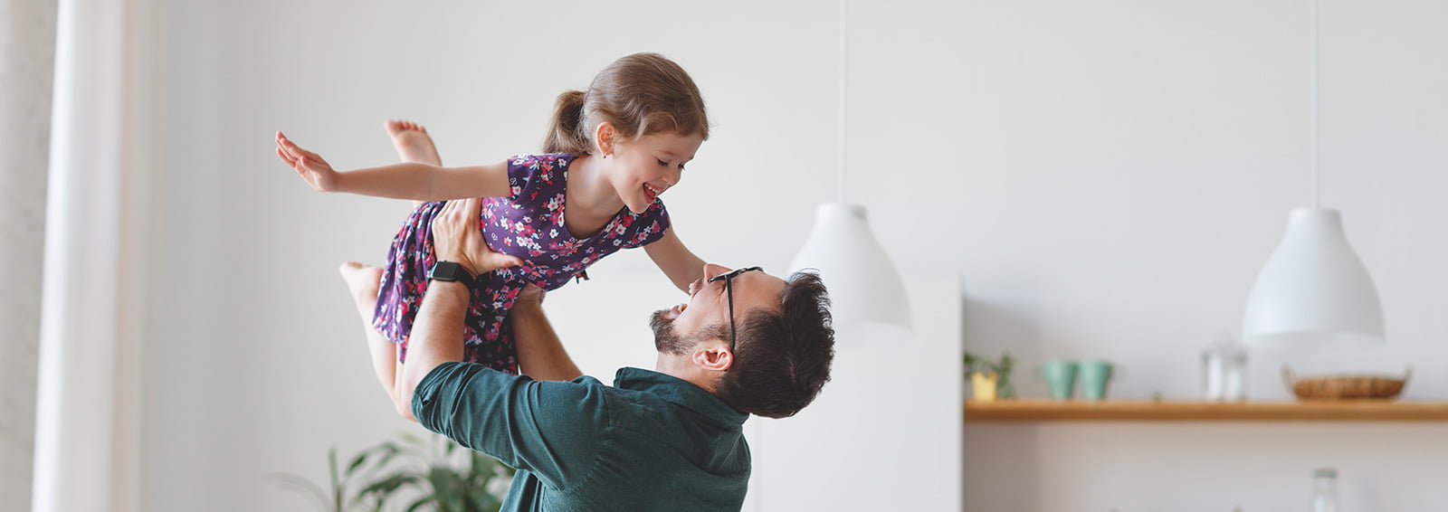 father lifting daughter in air